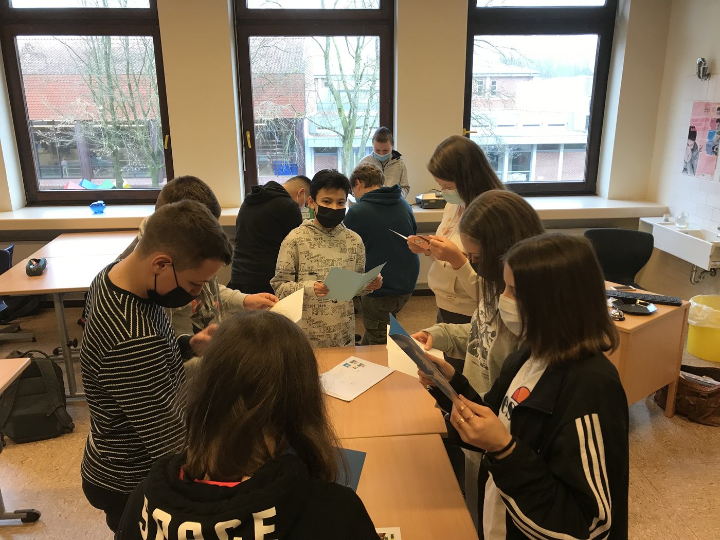 Schuelerinnen und Schueler arbeiten in Kleingruppen an Erasmus-Aufgaben.